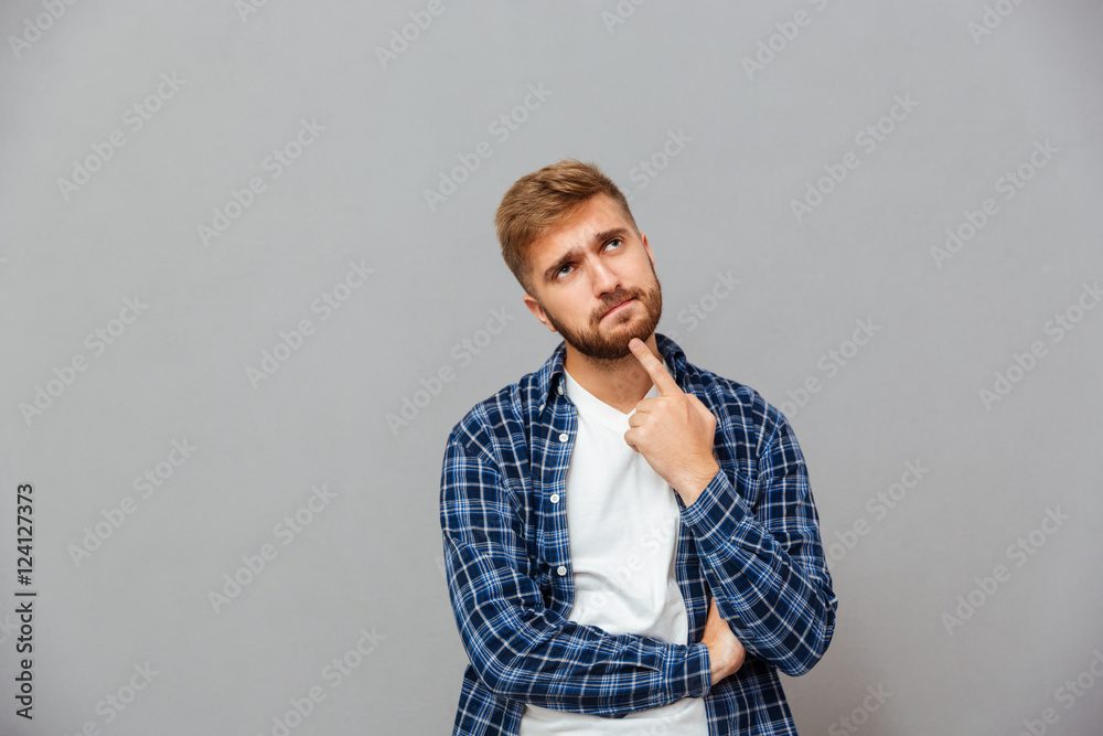 Portrait of a pensive man touching his beard with hand Portrait of a pensive man touching his beard with hand
