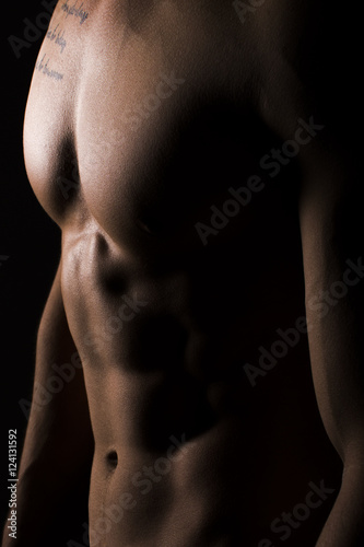 Muscular Torso of Sexy Young Male Close Up on Black Background
