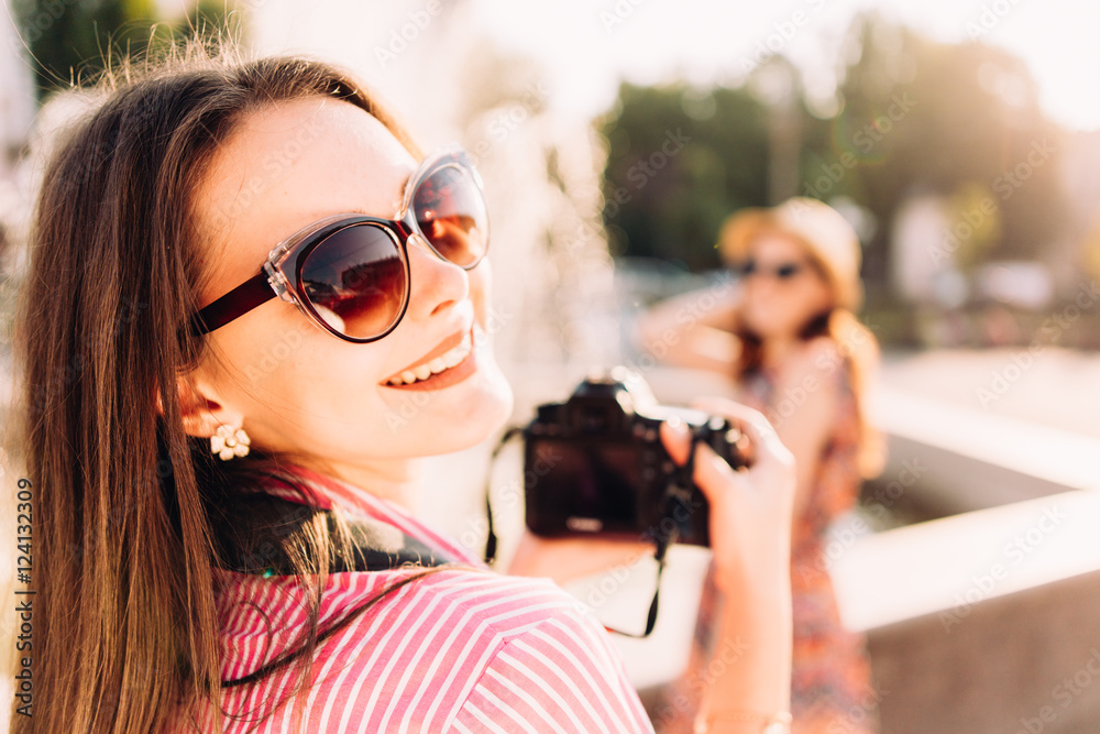 girls taking pictures on film camera outdoor in the city girls taking pictures on film camera outdoor in the city