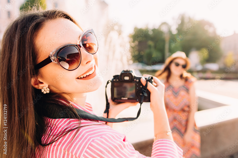 girls taking pictures on film camera outdoor in the city girls taking pictures on film camera outdoor in the city