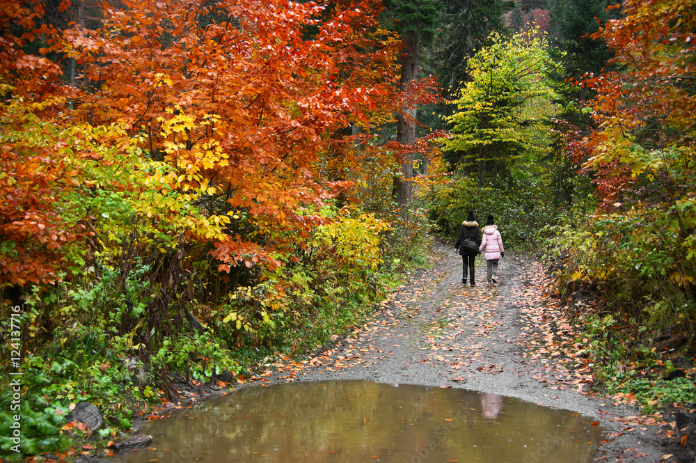 Mother and daughter in autumn forest