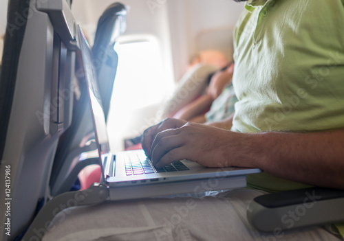 Businessman with laptop in airplane