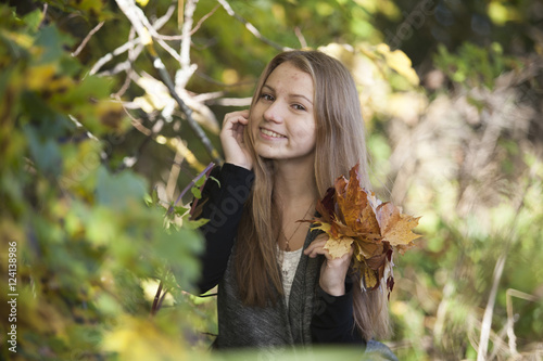 Girl with a cute smile on  sunny autumn day