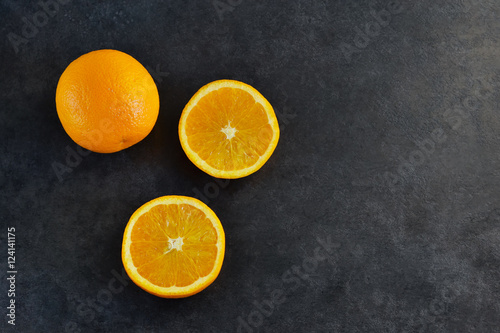 Fresh, juicy orange on the black concrete background © zefirchik06