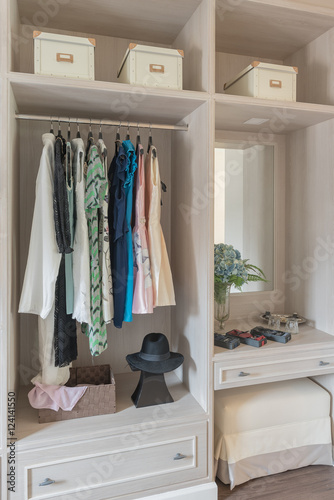 modern wooden wardrobe with clothes hanging on rail in walk in c © 290712