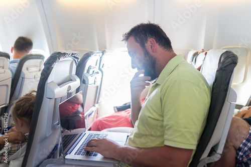 Businessman with laptop in airplane