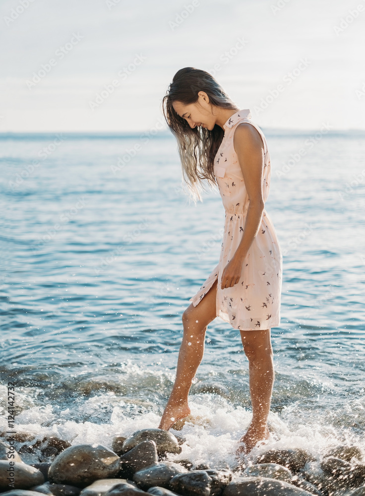 Naklejka premium Woman walking on pebble beach