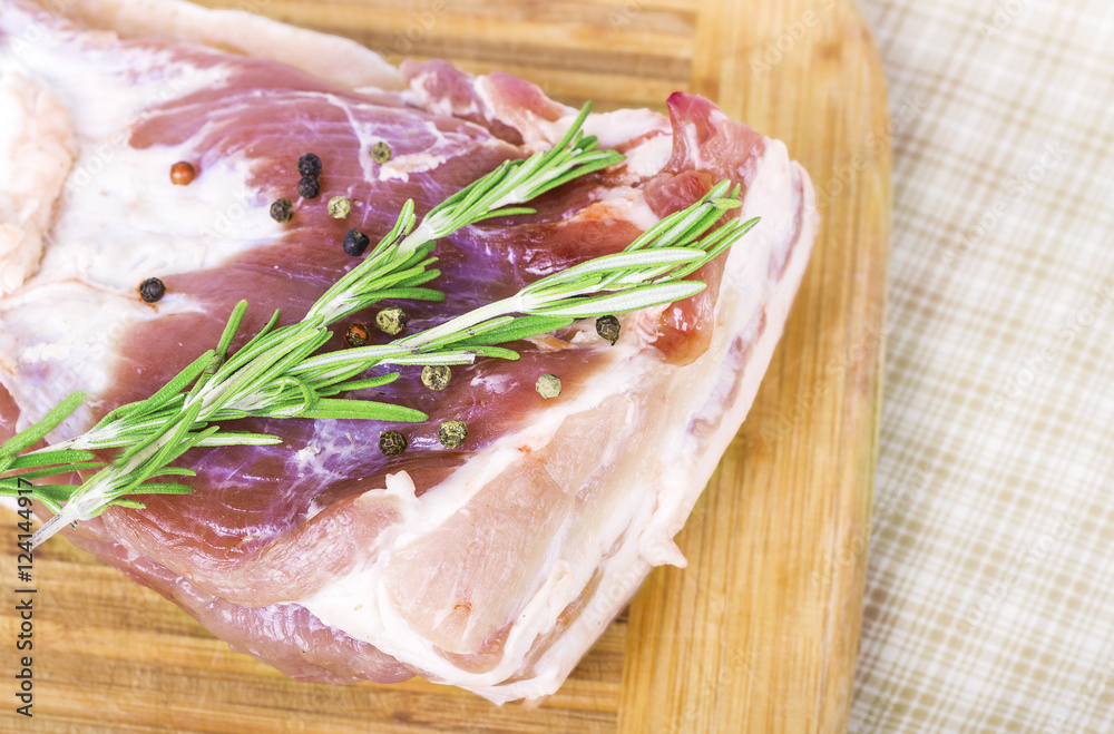 Fresh meat : raw pork with pepper sweet pea and rosemary on wooden board Fresh meat : raw pork with pepper sweet pea and rosemary on wooden board