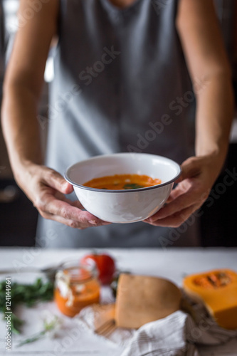 Unrecognizable woman holding a halloween pumpkin soup