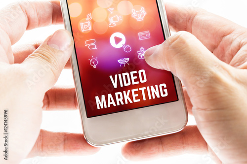 Close up Two hand holding mobile phone with Video marketing word