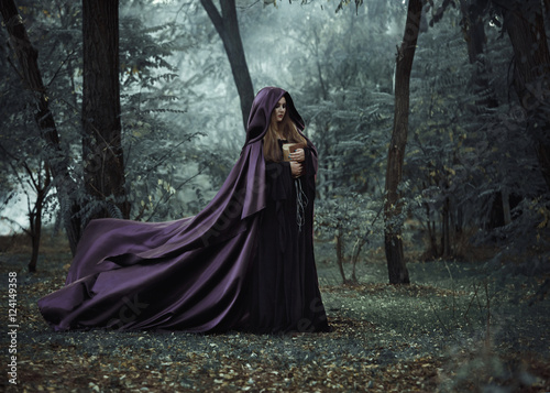  Wicked witch in a long dark cloak wandering in woods