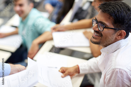 happy student with exam test or handout at lecture photo