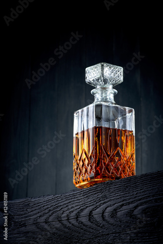 Carafe of whiskey on a black wooden table