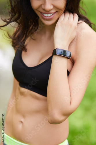 Closeup of sporty woman looking at smart watch