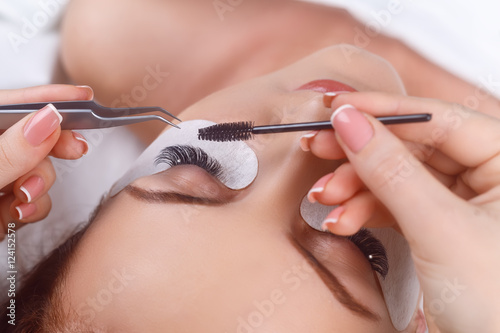 Eyelash Extension Procedure. Woman Eye with Long Eyelashes. Eyelashes with rhinestone. Lashes, close up, macro, selective focus.