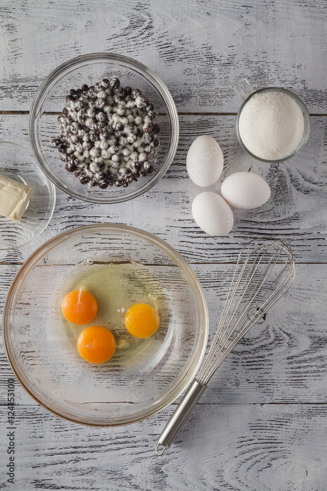 Eggs and whisk on wooden table Eggs and whisk on wooden table