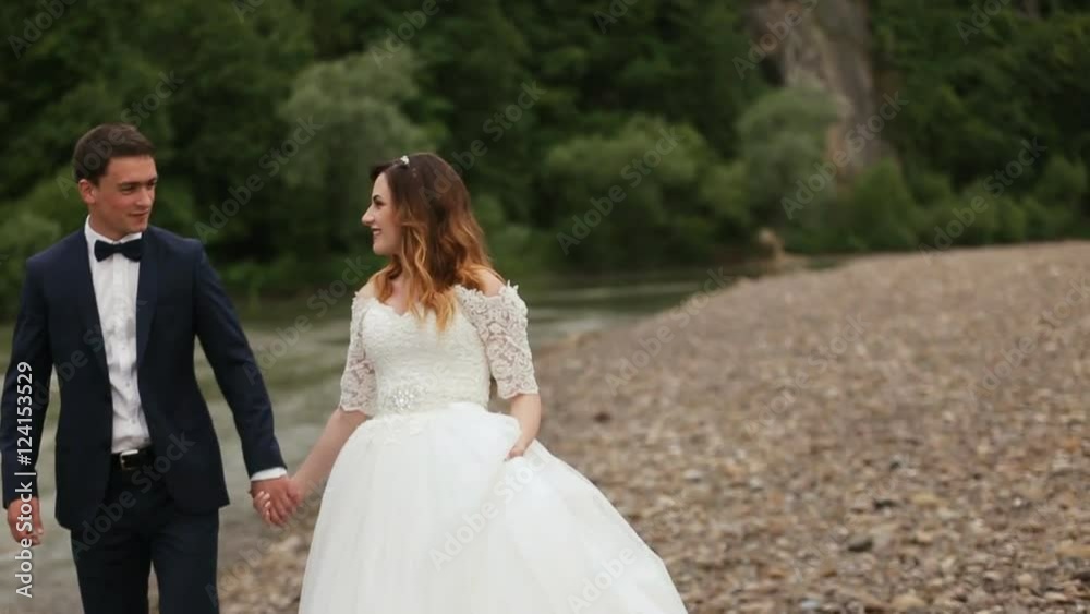 Bride and groom holding hands near the river Bride and groom holding hands near the river