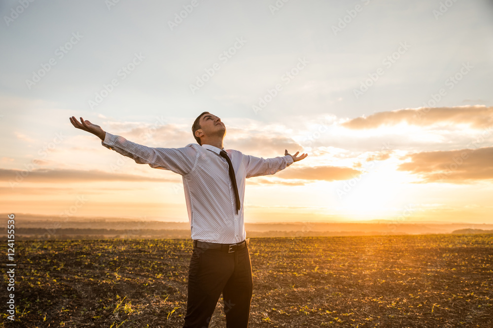 Thankful Businessman with Open Arms at the Field on sunset Thankful Businessman with Open Arms at the Field on sunset