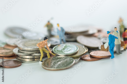 Miniature people on coins finance concept