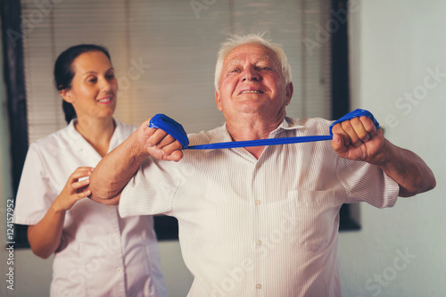 Senior man doing exercises using a strap to extend and strenthen