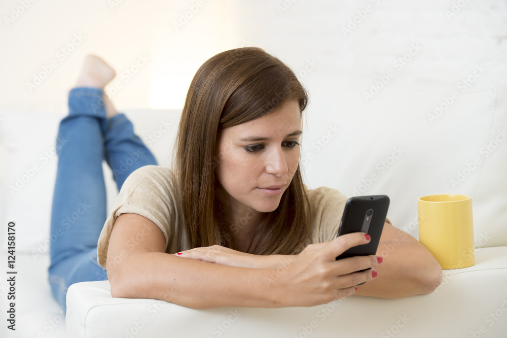 beautiful woman with coffee happy on couch texting networking on mobile phone relaxed beautiful woman with coffee happy on couch texting networking on mobile phone relaxed