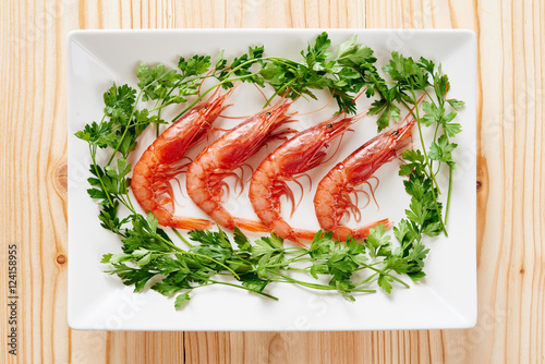 Raw prawns and parsley on white dish