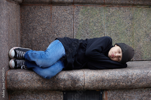 young homeless boy sleeping on the street © Roman Bodnarchuk