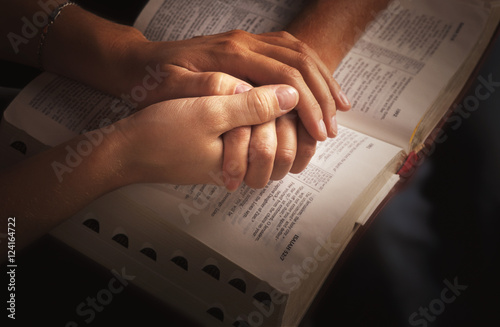 Holding Hands And Praying Over The Bible