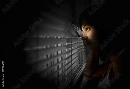 Girl Peeking Out Of Window photo