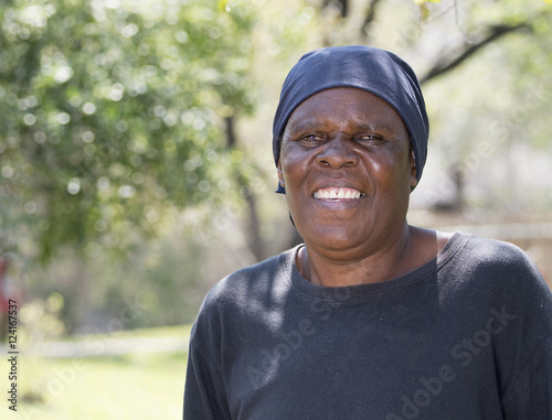 Smiling Older South African Woman Standing in Yard Where she is Gardener