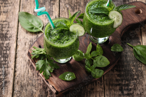 Fresh green smoothie with straws on a wooden table,healthy vegan food