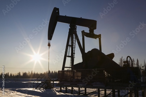 Edson, Alberta, Canada; Silhouette Of A Pump Jack With A Sunburst In Winter photo