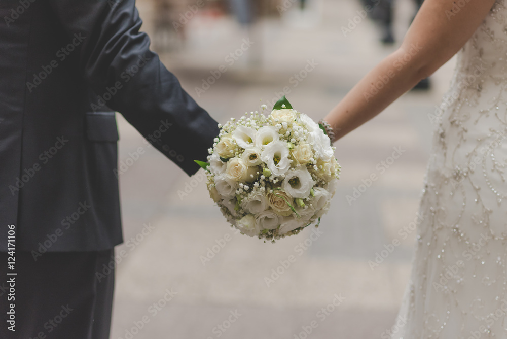 Wedding couple hands with bouquet 