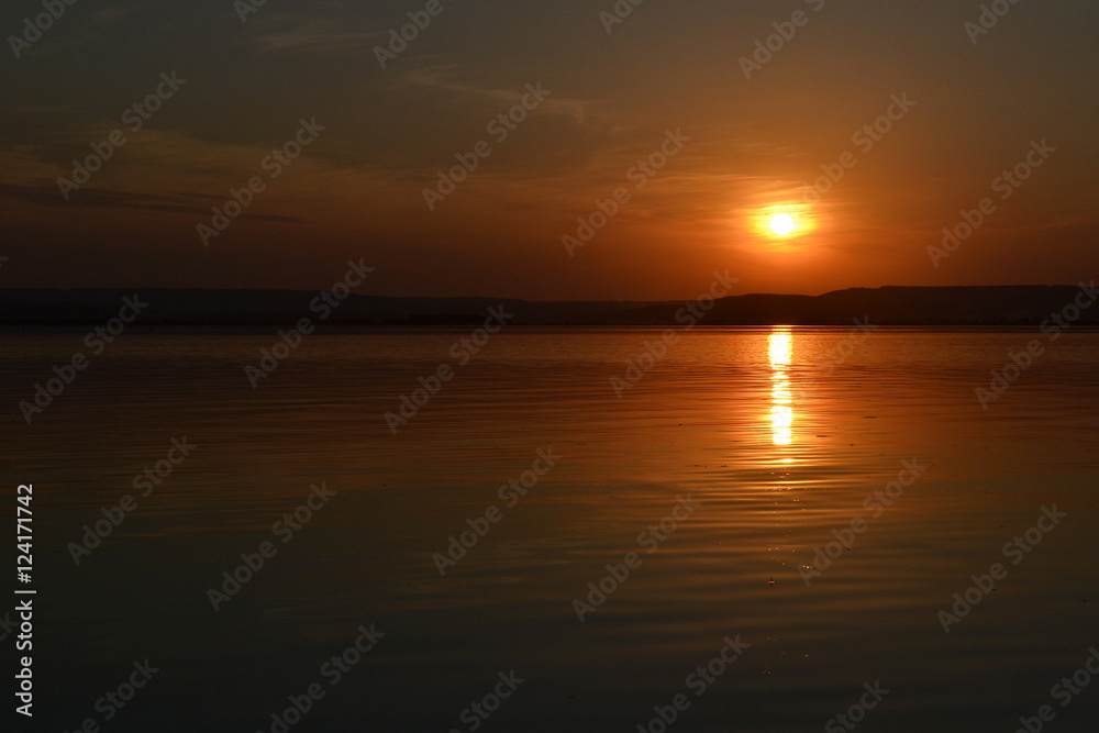 The sun over the river. Sunset on the river Volga. Solar path.
