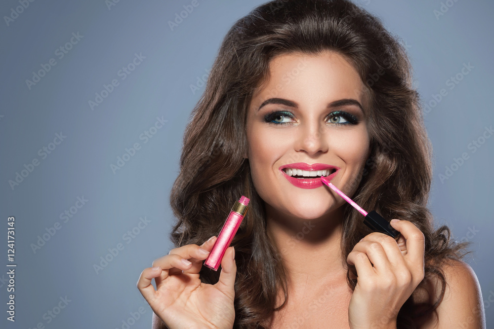Beautiful woman applying lip-gloss Beautiful woman applying lip-gloss