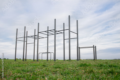 Public training ground in a park. street workout and horizontal bar on green grass