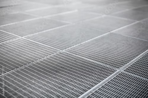 Metal ventilation grille on a sidewalk with shallow depth of fie
