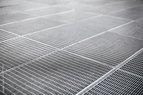 Metal ventilation grille on a sidewalk with shallow depth of fie