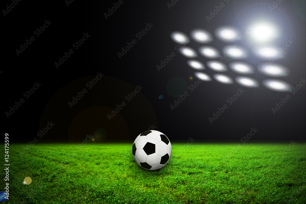 Soccer ball on grass against black background