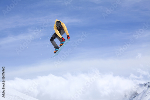 Snowboarder jumping in mountains, extreme sport.