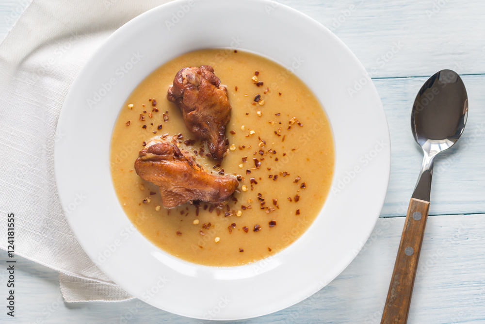Portion of pea cream soup with smoked chicken wings Portion of pea cream soup with smoked chicken wings