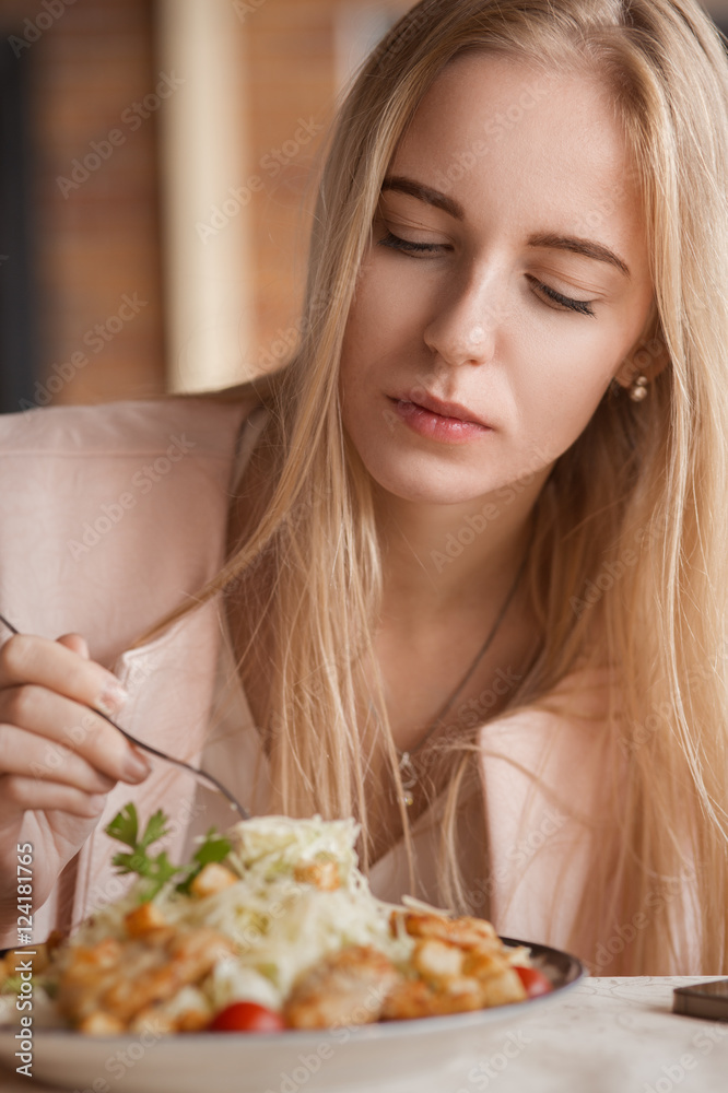 beautiful sad woman in cafe eating salad