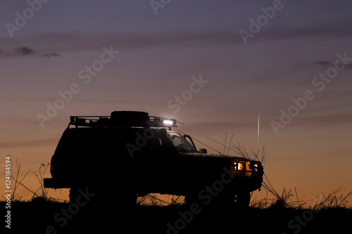 SUV silhouette on sunset sky background