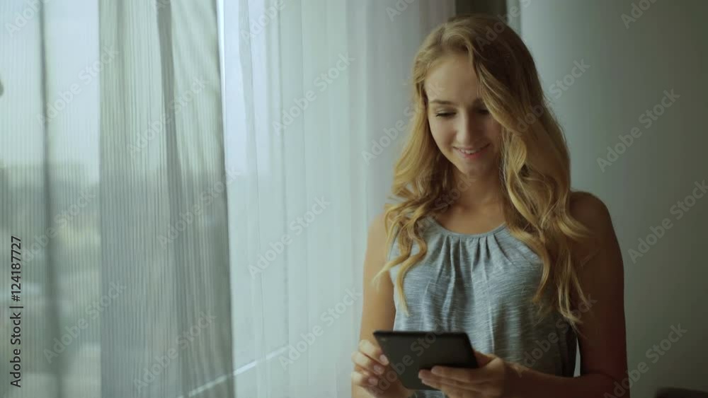 Close up portrait of happy young woman looking at touchscreen tablet Close up portrait of happy young woman looking at touchscreen tablet