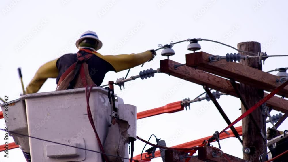Utility workers in cherry picker working on power line