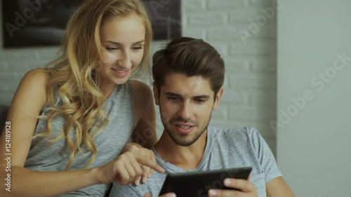 Amazing girlfriend and her man using tablet at home.