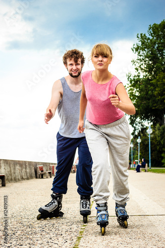 Active young people friends rollerskating outdoor.