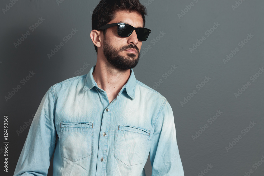 Young hipster bearded man with sunglasses - gray background