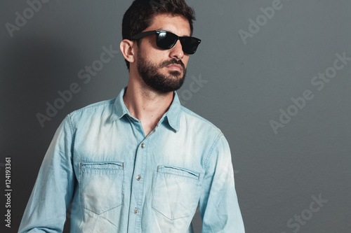 Young hipster bearded man with sunglasses - gray background