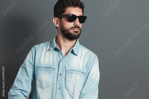 Young hipster bearded man with sunglasses - gray background